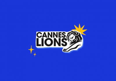 Fundo azul com logo do Cannes Lions 2023 na cor preta e detalhes amarelos, composta por um leão e o nome da premiação.